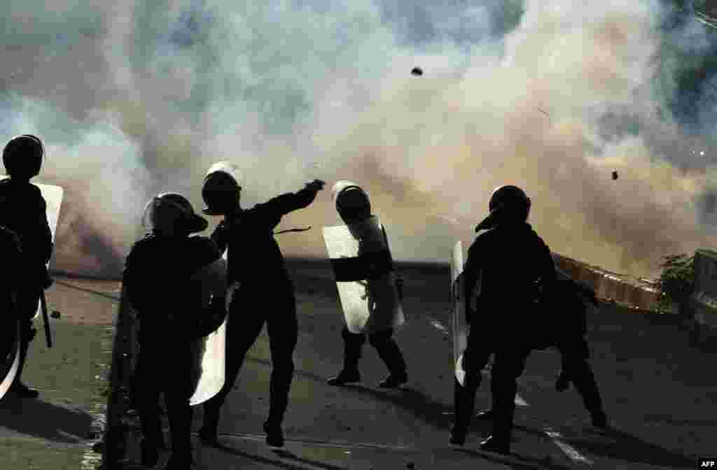 Honduran riot police throw tear gas at students of the National Autonomous University of Honduras, as they protest in demand of a reduction in the price of fuel in Tegucigalpa.