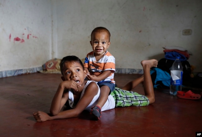 En esta foto del 27 de junio de 2018, los niños migrantes venezolanos juegan en el piso de la casa sin muebles que sus padres están alquilando y compartiendo durante los últimos dos años con otra familia venezolana en Cúcuta, Colombia.