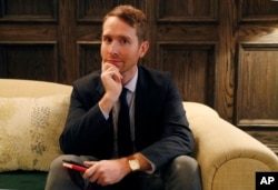 John Scott-Railton, a senior researcher at the Citizen Lab, an internet watchdog group, holds his cell phone which has its camera blocked by an adhesive sticker, as he poses for a photograph, Jan. 17, 2019, in New York.