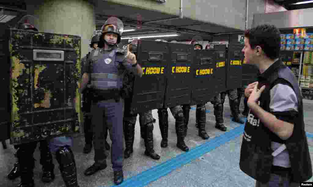A man stands in front of riot police inside Ana Rosa subway station during the fifth day of metro workers&#39; protest in Sao Paulo, Brazil, June 9, 2014.