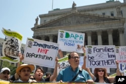 Demonstrators protest against a Supreme Court decision on immigration outside the New York Supreme court, Friday, June 24, 2016, in New York.