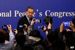 FILE - China's Foreign Minister Wang Yi leaves the stage after a press conference on the sidelines of the National People's Congress at the media center in Beijing, March 8, 2018.