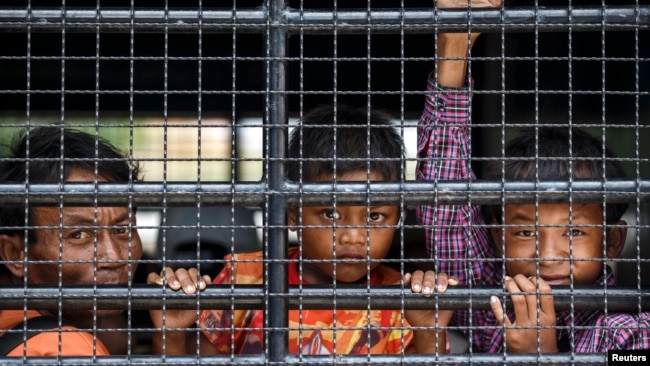 Cambodian migrants look through grills of a truck as they wait to cross the Thai-Cambodia border at Aranyaprathet in Sa Kaew, June 15, 2014. A high percentage of migrants have at some point experienced exploitation and human trafficking, official figures show.