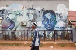 Seorang pria berjalan melewati grafiti calon presiden oposisi Uganda Robert Kyagulanyi, juga dikenal sebagai Anggur Bobi, di Kampala, Uganda 17 Januari 2021. (Foto: REUTERS/Baz Ratner)