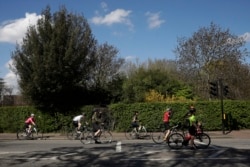 Cyclists spread out as they observe social distancing whilst waiting at a traffic light by Regent's Park, London.