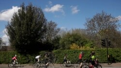 Ciclistas observan el distanciamiento social mientras esperan en un semáforo en Regent's Park, Londres, el sábado 4 de abril de 2020.