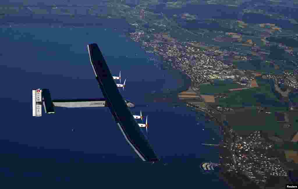 German test pilot Markus Scherdel steers the solar-powered Solar Impulse 2 aircraft over the Lake Murten during a training flight at its base in Payerne, Switzerland, Sept. 27, 2014. 