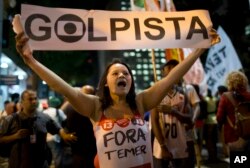 A demonstrator holds a sign that reads in Portuguese "Coup leader " during a march against acting President Michel Temer and in support of Brazil's suspended President Dilma Rousseff in Rio de Janeiro, Brazil, Aug. 29, 2016.