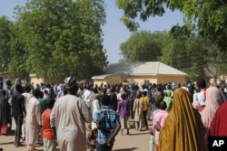 People gather outside the general hospital where the kidnapped girls from the Government Girls Science and Technical College Dapchi who were released are being treatedd, in Dapchi, Nigeria, March 21, 2018.