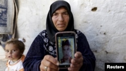 Amal Ibrahim, 57, shows a picture of her son Mohammad in rebel-held Kafrouma village near Idlib, Syria, March 20, 2016. Authorities detained her two sons, and she said she was told one of them, Abdullah, had died from torture. Mohammad's fate wasn't known.