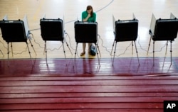 A voter casts a ballot in Georgia's primary election at a polling site in a high school gymnasium in Atlanta, March 1, 2016.