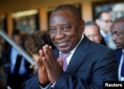 FILE - South African Deputy President Cyril Ramaphosa greets security personnel at the World Economic Forum on Africa 2017 meeting in Durban, South Africa, May 5, 2017.