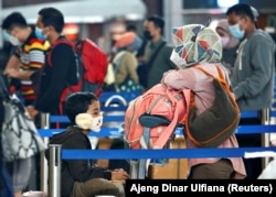 Orang-orang antre untuk check-in tiket dengan barang bawaan mereka di Bandara Soekarno-Hatta untuk kembali ke kampung halaman. (Foto: Reuters)