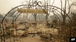 Un rótulo a la entrada de una casa destruida por las llamas en Middletown, California lee "Aquí es donde pertenezco".