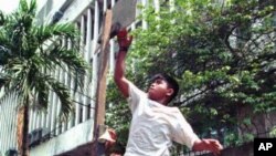 A Filipino street kid imitates a Michael Jordan slam dunk as they play their own kind of basketball at a back street in Manila.