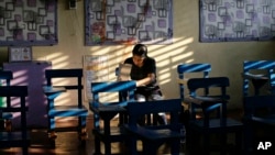 A Filipino woman votes during the country's midterm elections inside a polling center at a school in Manila, Philippines on Monday, May 13, 2019. 