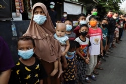 Sejumlah warga antre menerima bantuan dari Presiden Joko Widodo di tengah pandemi virus corona, di Jakarta, Jumat, 16 Juli 2021. (Foto: Willy Kurniawan/Reuters)