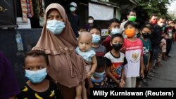 Sejumlah warga antre menerima bantuan dari Presiden Joko Widodo di tengah pandemi COVID-19 di Jakarta, Jumat, 16 Juli 2021. (Foto: Willy Kurniawan/Reuters)