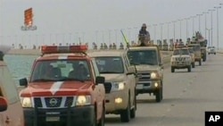 An image grab taken from Bahrain TV shows 'vanguard' of a contingent of Gulf troops arriving in the unrest-wracked Kingdom of Bahrain across a causeway from Saudi Arabia, March 14, 2011
