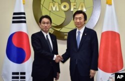 South Korean Foreign Minister Yun Byung-Se, right, and his Japanese counterpart Fumio Kishida pose for a photo at the start of their meeting at Foreign Ministry in Seoul Monday, Dec. 28, 2015.