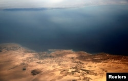 FILE - An aerial view the Red Sea coast shows the islands of Tiran and Sanafir is through the window of an airplane, near Sharm el-Sheikh, Egypt, Nov. 1, 2016.