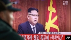 ຊາວເກົາຫລີໃຕ້ຄົນນຶ່ງ ກຳລັງເບິ່ງຜູ້ນຳເກົາຫລີເໜືອ ທ່ານ Kim Jong Un ກ່າວຄຳປາໄສປີໃໝ່ ຜ່ານທາງໂທລະພາບ. 