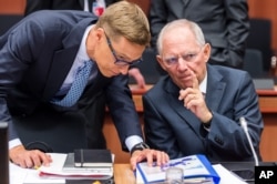 German Finance Minister Wolfgang Schaeuble, right, talks with Finnish Finance Minister Alexander Stubb during a meeting of eurogroup finance ministers at the EU Council building in Brussels, Belgium, July 13, 2015.