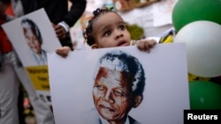 Bé trai 2 tuổi cầm hình cựu Tổng thống Nam Phi Nelson Mandela.