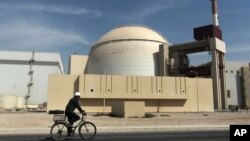 FILE - A worker rides in front of the reactor building of the Bushehr nuclear power plant, just outside Bushehr, Oct. 26, 2010. 