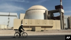 FILE - A worker rides in front of the reactor building of the Bushehr nuclear power plant, just outside Bushehr, Oct. 26, 2010. 