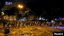 Voluntarios médicos fueron fotografiados saliendo del campus de la Universidad de Hong Kong, el martes. Al menos 100 manifestantes permanecen dentro del campus universitario. 