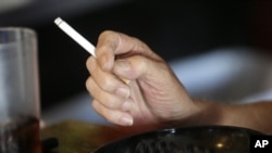 FILE - Patron smokes cigarette inside Kajun's Pub, in New Orleans, Louisiana, April 21, 2015.