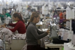 FILE - Employees work at a factory supplier of the H&M brand in Kandal province, Cambodia, December 12, 2018.