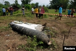 Warga setempat mendatangi lokasi ditemukannya kepingan pesawat turboprop ATR-72 yang jatuh di dekat Pakse, Laos (17/10).