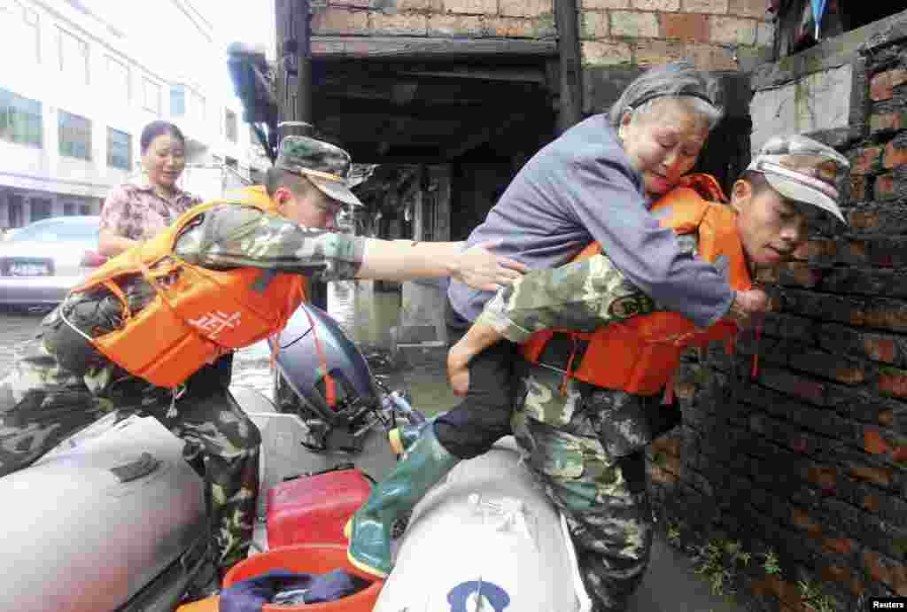 Paramilitary police carry an elderly woman off a raft as they rescue trapped residents after Typhoon Fitow hit Taizhou, Zhejiang province, China, Oct. 8, 2013.