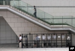 People gather at the smoking area in Tokyo's Shiodome business district, Aug. 8, 2017.