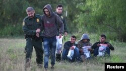 FILOE - U.S. Border Patrol agents apprehend undocumented migrants after they illegally crossed the U.S.-Mexico border, in Mission, Texas, April 9, 2019.