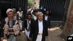 Yemeni tribal leader Sadiq al-Ahmar (C) is flanked by armed guards as he walks out of his residence in the al-Hasaba neighborhood of north Sana'a, May 26, 2011.