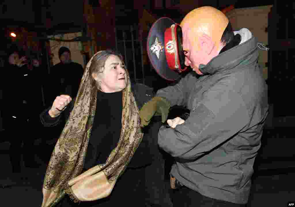 A pro-Russian woman, a believer of Ukrainian Orthodox Church (Moscow Patriarchy), attacks an activist mocking Russian President Vladimir Putin during a protest of Ukrainian nationalists at Kiev-Pecherskaya Lavra Cathedral in Kyiv.
