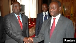 Michel Am-Nondokro Djotodia (L), leader of Central African Republic's (CAR) Seleka rebel alliance, shakes hands with CAR's President Francois Bozize (R) during peace talks with delegations representing the government and the opposition rebels, Jan. 11, 2013.