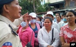 A Cambodian police keeps order outside of the court.