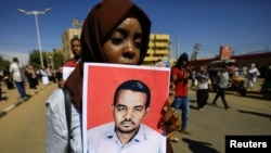 Una mujer sudanesa lleva un retrato del maestro Ahmed al-Khair mientras celebra después de la sentencia de muerte de 29 miembros del servicio nacional de inteligencia al colgarse por el asesinato de un maestro detenido en febrero durante las protestas. Foto: REUTERS.