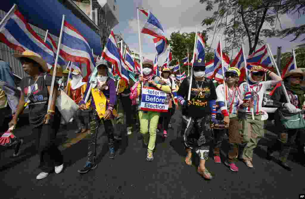 Anti-government protesters wave Thai national flags as they march through central Bangkok, Feb. 7, 2014. 
