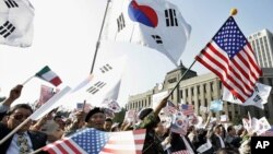 资料照：美韩同盟的支持者在一个集会上挥舞美国和韩国国旗。（2005年10月24日）