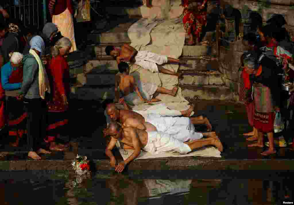 Devotees offer prayers by rolling on the ground during the Swasthani Brata Katha festival in Bhaktapur, Nepal, Jan. 21, 2019.