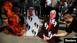 Des Palestiniens brûlent des portraits du président américain Donald Trump, du prince héritier d'Abou Dhabi Mohammed ben Zayed et du Premier ministre israélien Benjamin Netanyahu lors d'une manifestation à Naplouse en Cisjordanie occupée par Israël le 14 août 2020.