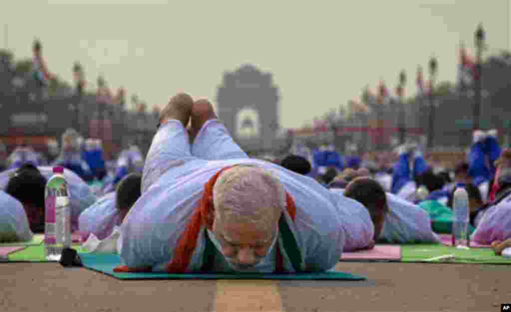 Indian Prime Minister Narendra Modi lies down on a mat as he performs yoga along with thousands of Indians on Rajpath, in New Delhi, India, Sunday, June 21, 2015. Millions of yoga enthusiasts are bending their bodies in complex postures across India as th