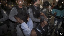 A protester, who is an Israeli Jews of Ethiopian origin, is carried by policemen during a demonstration against what they say is police racism and brutality, after the emergence last week of a video clip that showed policemen shoving and punching a black soldier in a protest at Rabin Square in Tel Aviv May 3, 2015.