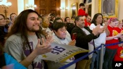Supporters of a bill to raise California's minimum wage celebrate outside the state Senate Chamber after the measure was approved by the Senate, March 31, 2016, in Sacramento, California.