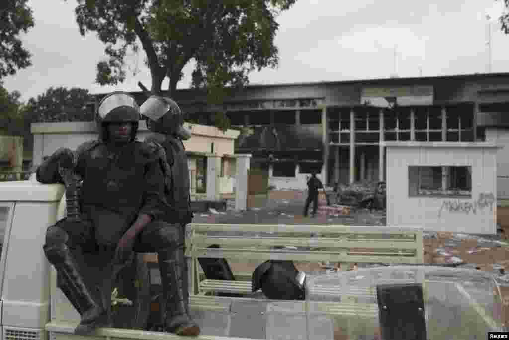 Des policiers montent la garde devant l&rsquo;entrée de l&rsquo;immeuble du parlement incendié à Ouagadougou, Burkina Faso. 
